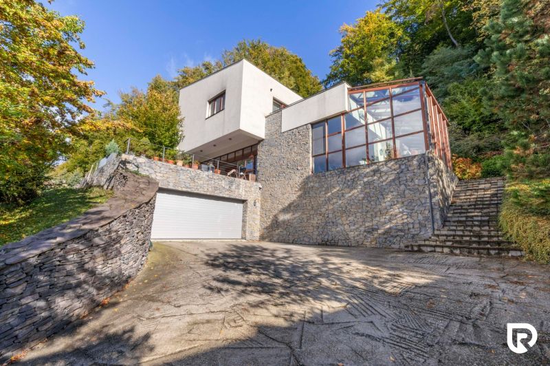 Ein Einfamilienhaus in der Karpatská-Straße in Marianka, umgeben von Grün mit einer verglasten Terrasse.