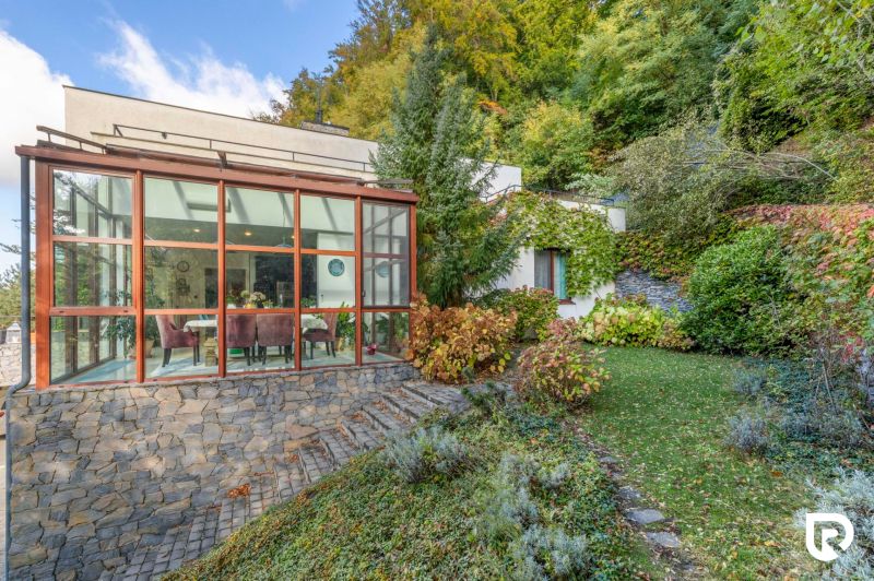 Ein Einfamilienhaus in der Karpatská-Straße in Marianka mit einem verglasten Wintergarten und einem gepflegten Garten.
