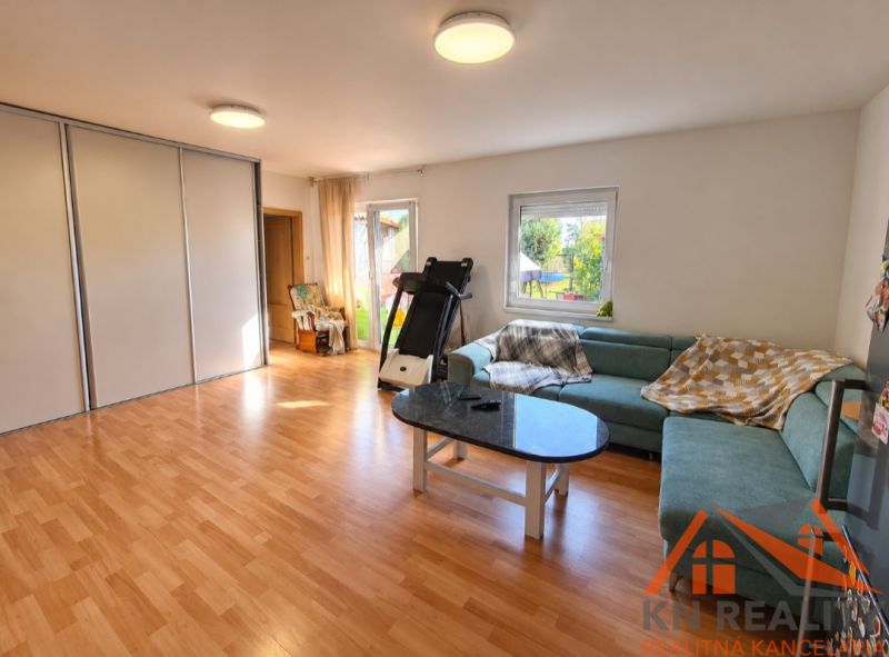 Wohnzimmer in einem Einfamilienhaus mit Holzboden und einem grünen Sofa.