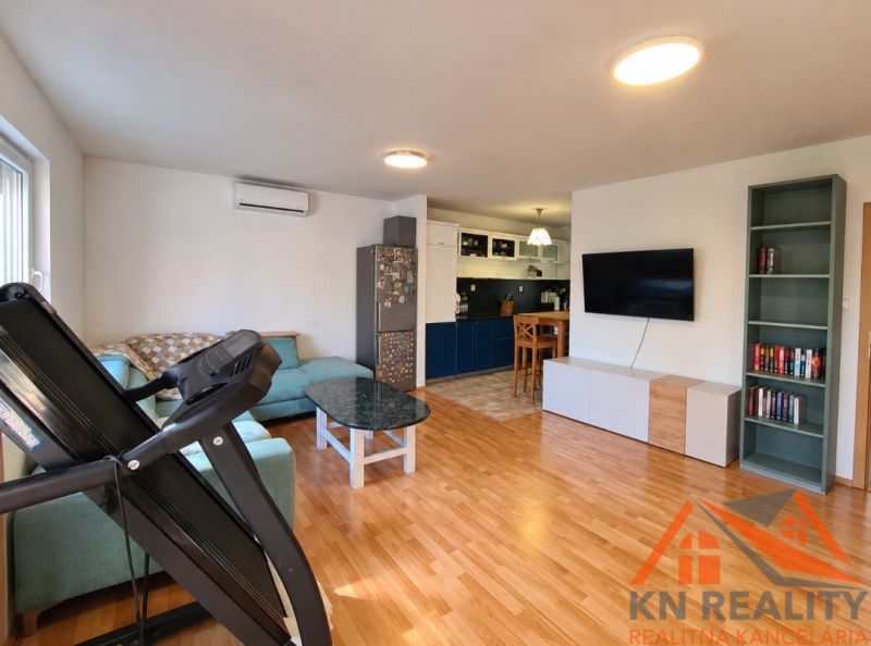 Wohnzimmer in einem Einfamilienhaus mit Holzboden, Sofa und Fernseher.