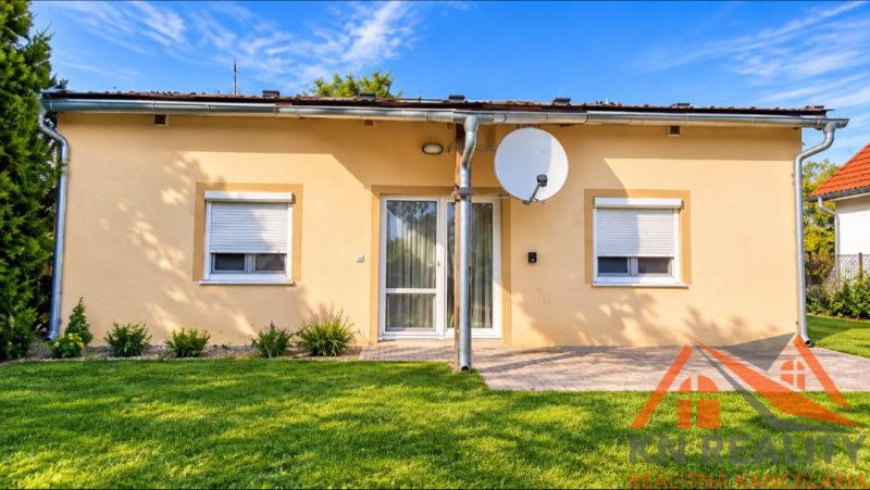 Ein Einfamilienhaus in Martovce mit weißen Fenstern, einer Satellitenschüssel und gepflegtem Rasen.