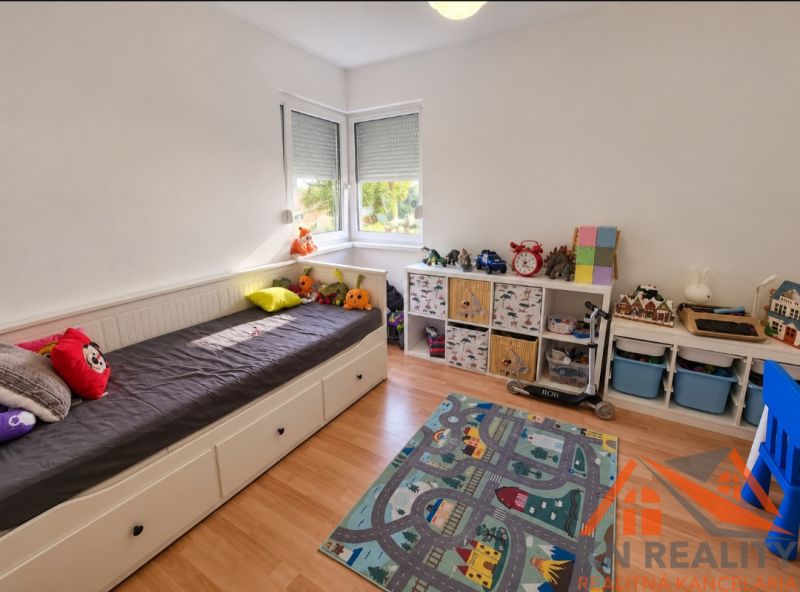 Kinderzimmer in einem Einfamilienhaus mit Bett und Stauraum, Boden mit Holzdekor.