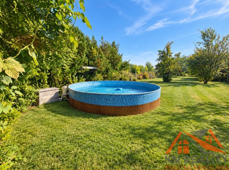 Draußen in Martovce bei einem Einfamilienhaus, ein runder Pool auf dem Rasen, umgeben von Grün.