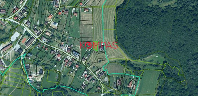 Luftaufnahme von Wohnbaugrundstücken in der Gemeinde Podzámčok, umgeben von Grünflächen und Parzellen.