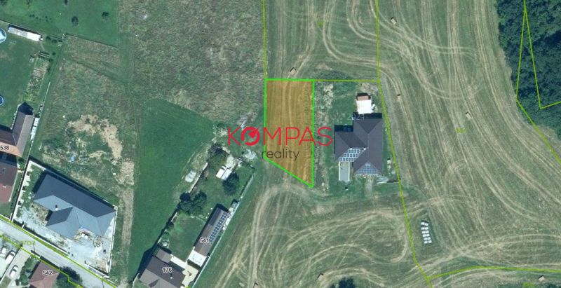 Grundstücke für Wohnzwecke in Podzámčok mit Umgebung von Häusern und landwirtschaftlichen Flächen.