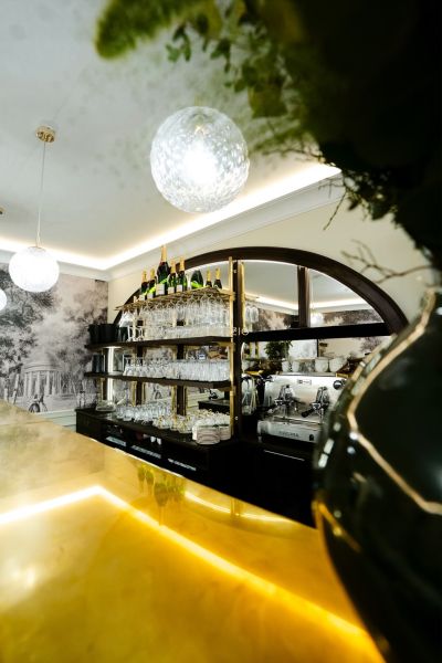 Obchodsräume mit einer Bar, Regalen mit Gläsern und einer Kaffeemaschine.