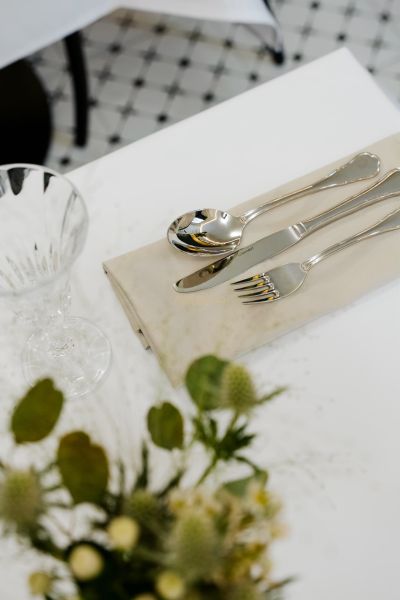 Ein gedeckter Tisch mit Besteck und Glas, dekoriert mit Blumen auf dem Tisch.