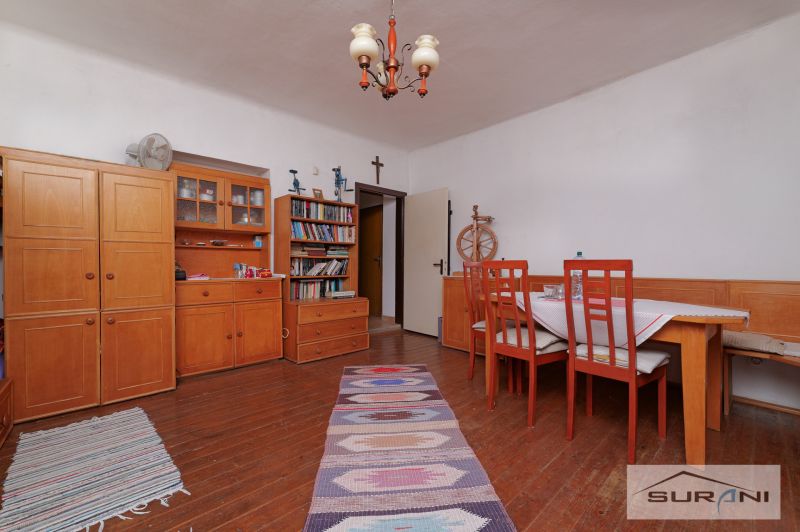 Esszimmer in einem Einfamilienhaus mit Holzmöbeln, Büchern und einem Boden mit Holzdekor.