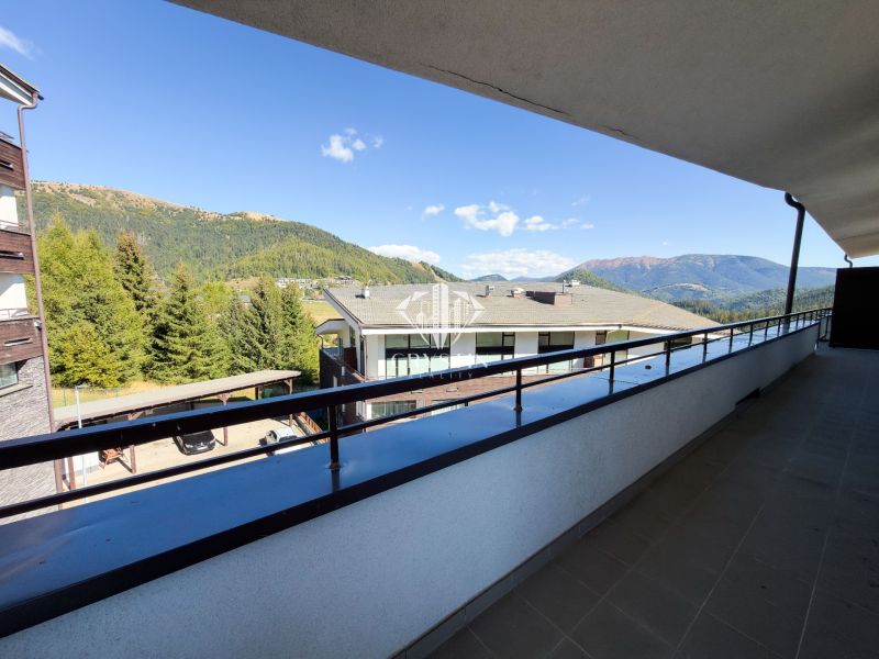 Der Balkon der 3-Zimmer-Wohnung in Donovaly bietet einen Blick auf die Berge und die Dächer der Gebäude.