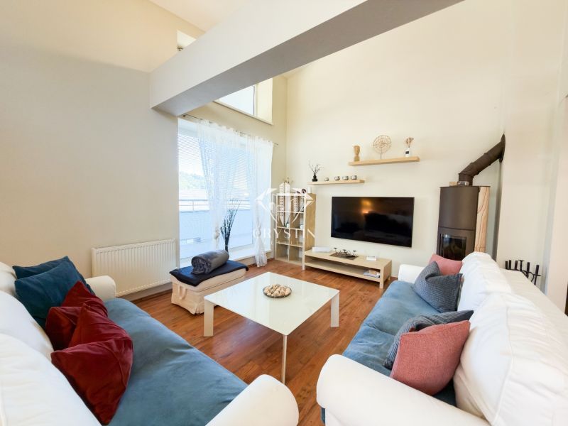 Wohnzimmer in einer 3-Zimmer-Wohnung mit Holzboden, bequeme Sofas, Fernseher.