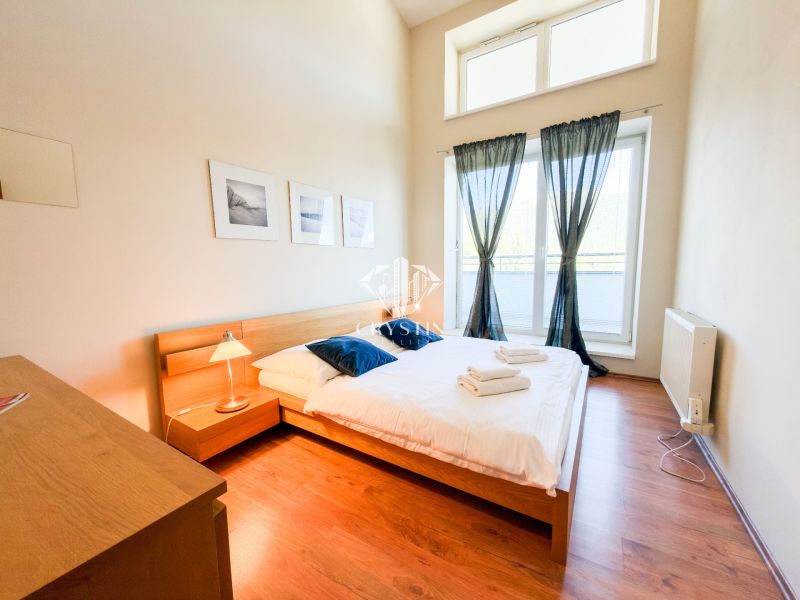 Schlafzimmer in einer 3-Zimmer-Wohnung mit Holzboden und großen Fenstern.