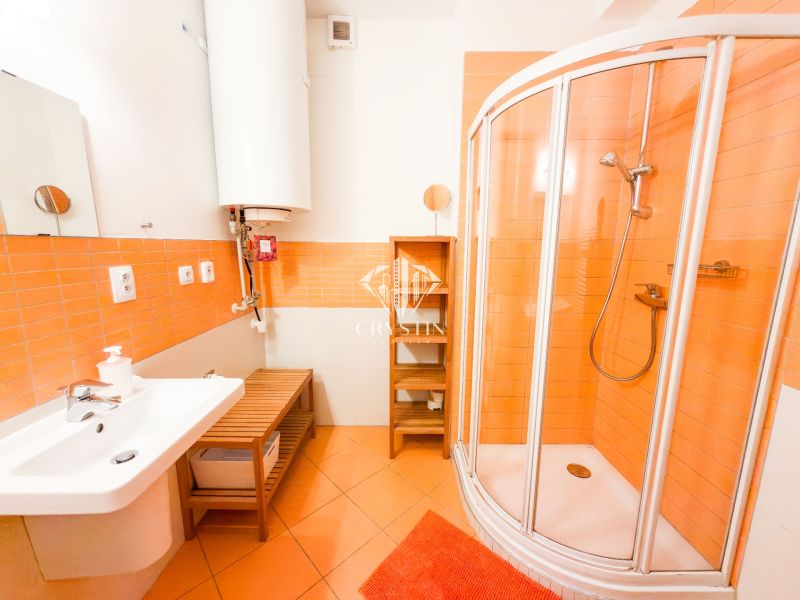 Badezimmer in einer 3-Zimmer-Wohnung mit orangefarbenen Fliesen, Duschkabine und weißem Waschbecken.