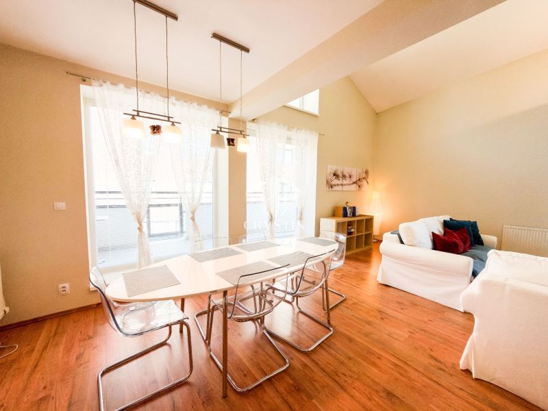 Wohnzimmer mit großen Fenstern, Sofas und Holzboden in einer 3-Zimmer-Wohnung.