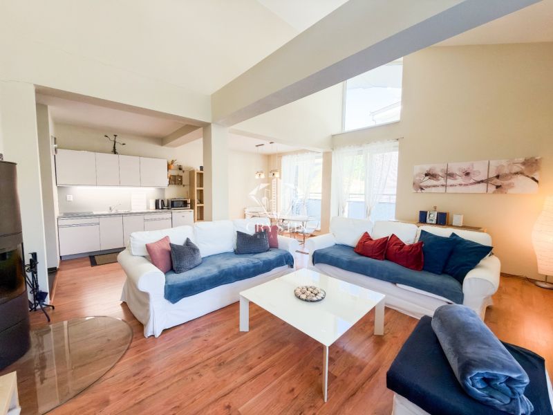 Wohnzimmer in einer 3-Zimmer-Wohnung mit Holzbodenoptik und heller Couch.
