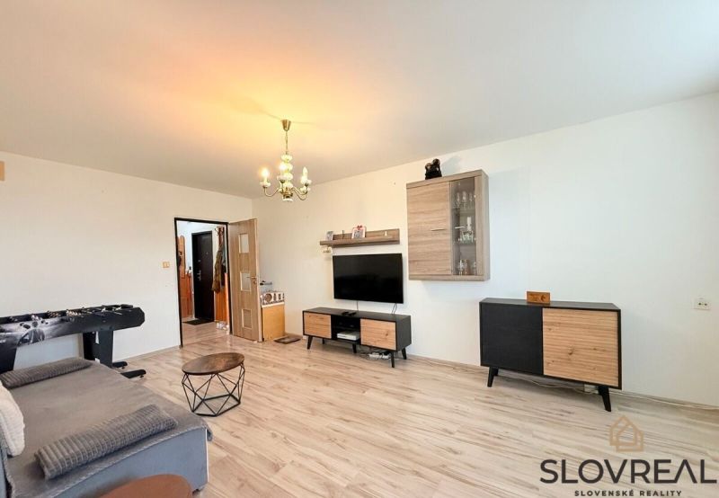 Wohnzimmer in einer 3-Zimmer-Wohnung mit Holzboden und Möbeln.