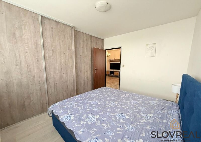 Schlafzimmer mit Bett, Einbauschrank und Durchgang zum Wohnzimmer in einer 3-Zimmer-Wohnung.