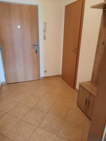 Eingangsflur in einer 2-Zimmer-Wohnung mit Fliesenboden und Holztüren.