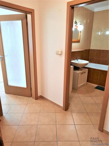 Flur mit Fliesenboden und Blick auf das Badezimmer in einer 2-Zimmer-Wohnung.