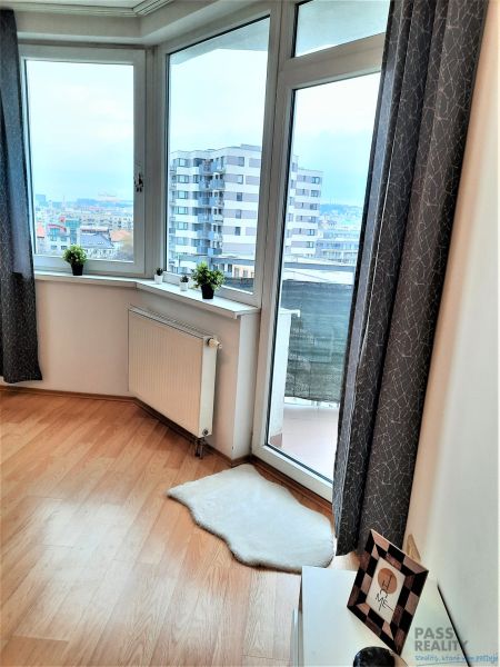 Große Fenster in einer 2-Zimmer-Wohnung mit einem Boden in Holzoptik.