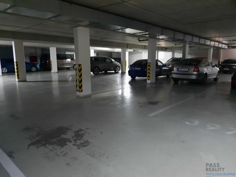 Unterirdischer Garagenstellplatz mit geparkten Autos in einer 2-Zimmer-Wohnung.