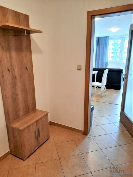 Diele in einer 2-Zimmer-Wohnung mit einer Garderobenwand und Blick ins Wohnzimmer mit Essbereich.