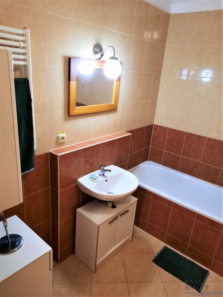 Badezimmer mit Waschbecken, Badewanne und Schrank in einer 2-Zimmer-Wohnung.