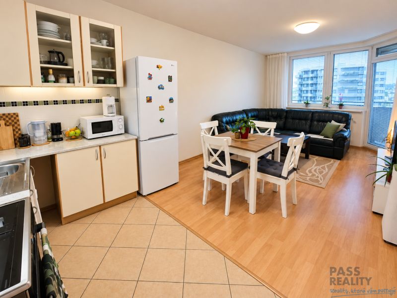Küche und Wohnzimmer in einer 2-Zimmer-Wohnung mit Holzboden, Esstisch und Sofa.