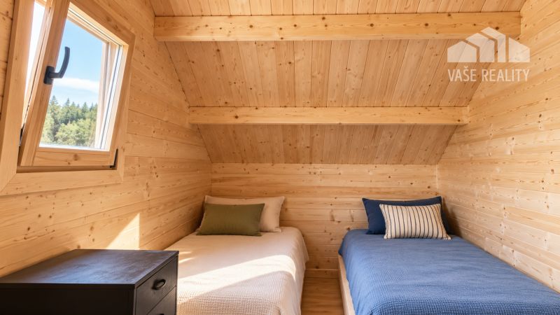 Ein hölzernes Interieur mit zwei Betten und einem Nachttisch, ein Fenster mit Blick auf den Wald.