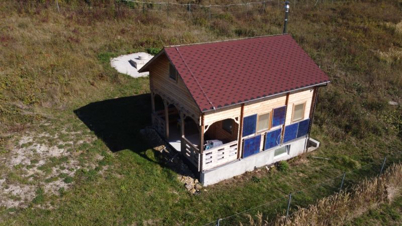 Eine Hütte in Horná Breznica mit Holzverkleidung und rotem Dach auf einem grünen Grundstück.