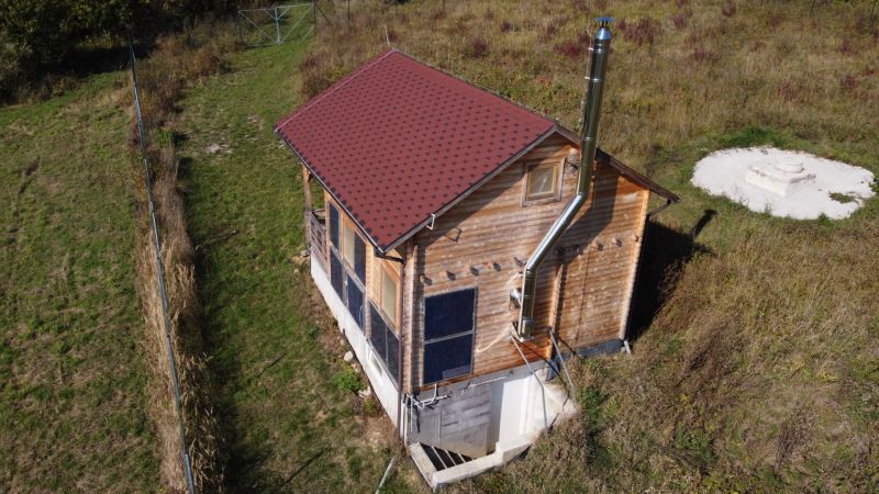 Eine Hütte in Horna Breznica am Hang mit Holzverkleidung und Solarmodulen.