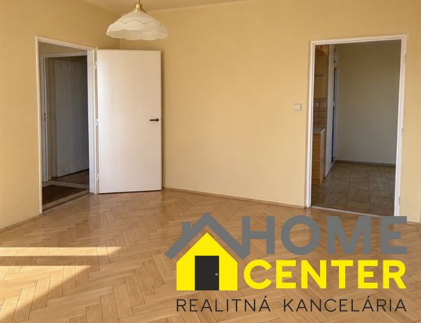 Ein Zimmer in einer 2-Zimmer-Wohnung mit einem Holzboden und zwei offenen Türen.