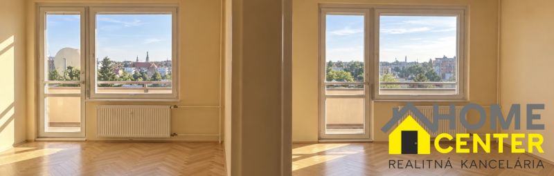 Ein Zimmer mit einem Holzboden in einer 2-Zimmer-Wohnung und Blick auf Komárno.