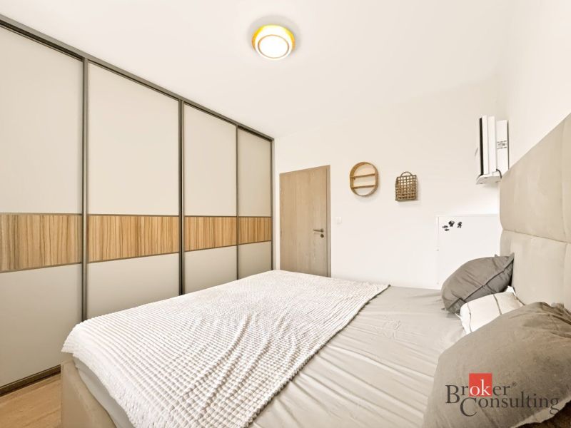 Schlafzimmer mit großem Einbauschrank und Bett in einer Zweizimmerwohnung.