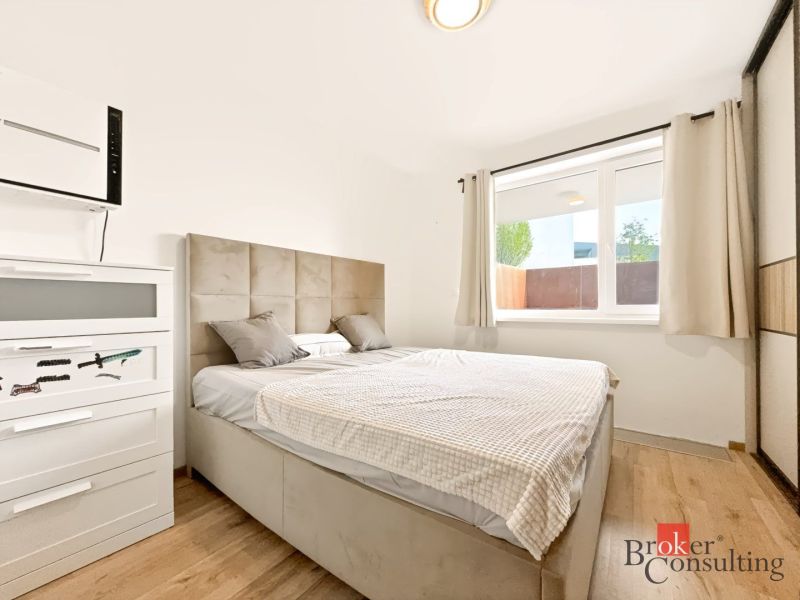 Schlafzimmer in einer 2-Zimmer-Wohnung mit Bett und Schrank, Boden mit Holzdekor.