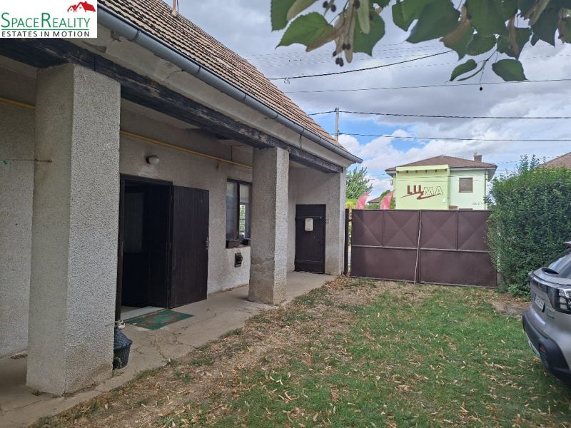 Ein älteres Gebäude mit Garten in der Hauptstraße in Viničné, geeignet für Grundstücke - Wohnen.