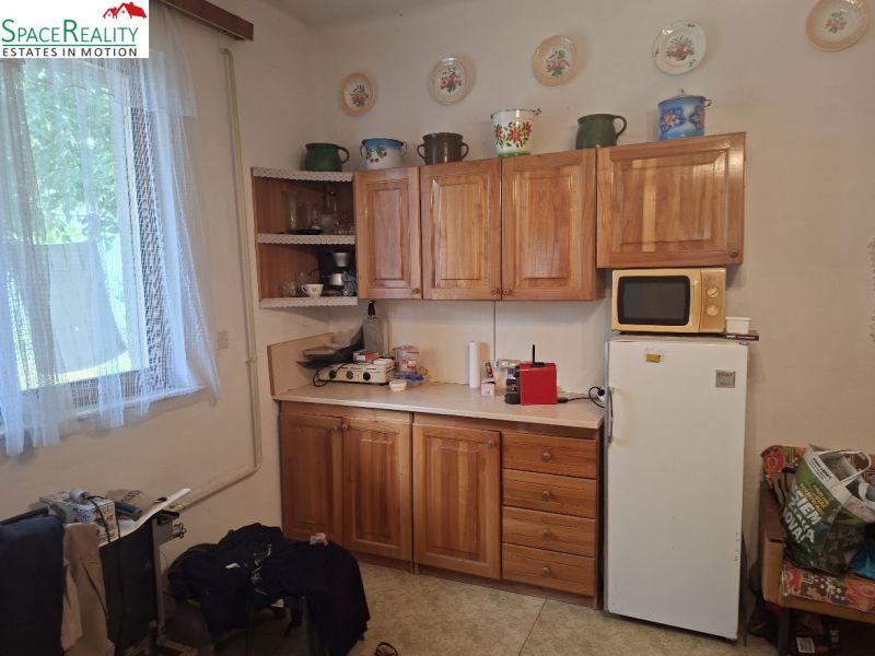 Küche mit Holzschränken, Mikrowelle und Kühlschrank, Grundstücke - Wohnen.