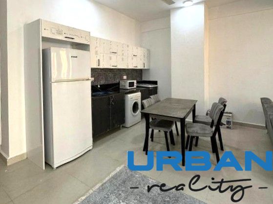 Küche in einer 2-Zimmer-Wohnung mit Esstisch, Kühlschrank und Waschmaschine.