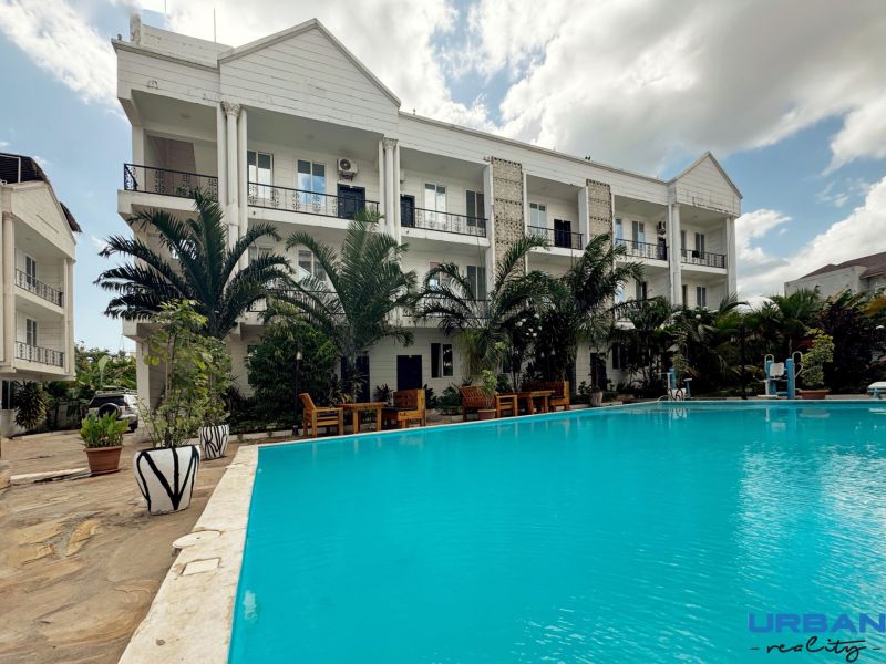 Gebäude am Pool und Palmen im Stadtteil Mbweni in Sansibar.
