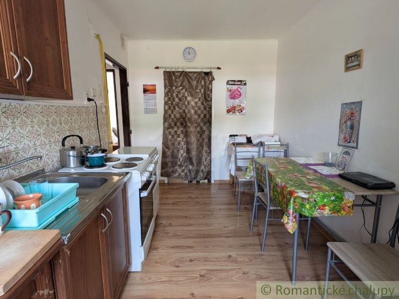 Küche in einer 2-Zimmer-Wohnung mit Herd, Spüle und Boden mit Holzdekor.
