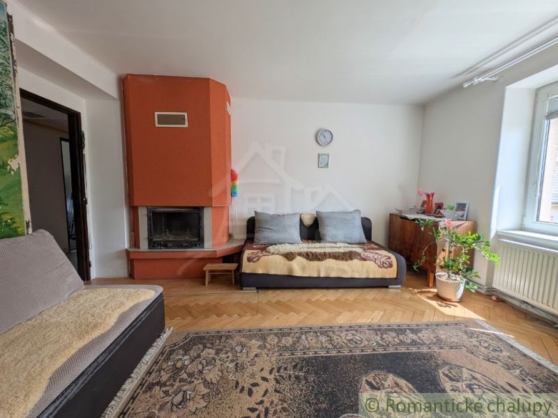 Wohnzimmer in einer Zweizimmerwohnung mit Kamin und Boden in Holzoptik.