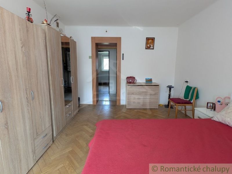 Ein Zimmer in einer 2-Zimmer-Wohnung mit einem Bett, einem Boden in Holzoptik und einem Schrank.