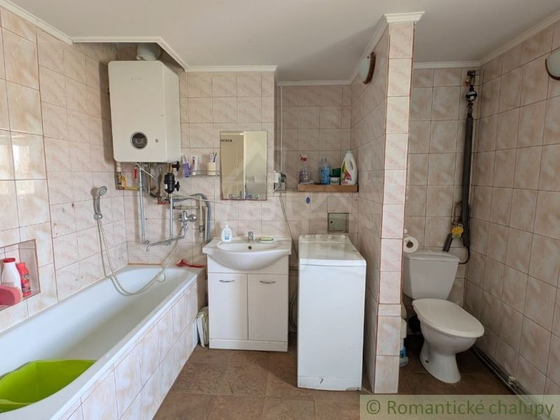 Badezimmer mit Dusche, Badewanne und Waschmaschine in einer 2-Zimmer-Wohnung.