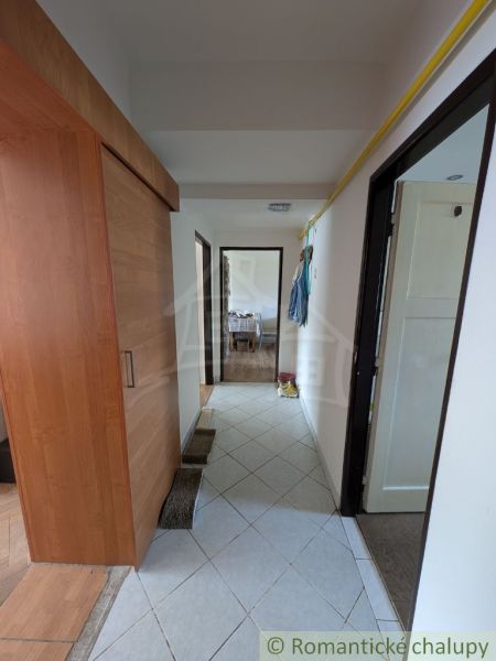 Der Flur in der 2-Zimmer-Wohnung mit Fliesen und einem Schrank auf dem Boden mit Holzdekor.