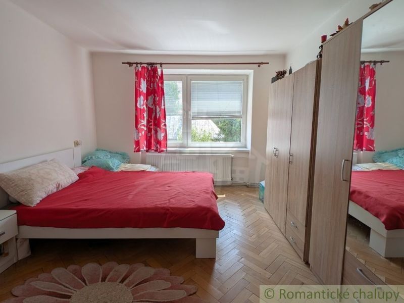 Schlafzimmer in einer 2-Zimmer-Wohnung mit Bett, Kleiderschrank und Boden mit Holzdekor.