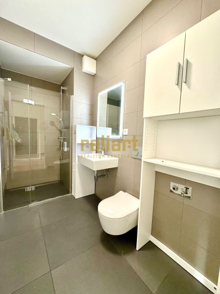 Badezimmer mit Toilette, Dusche und Stauraum in einer 2-Zimmer-Wohnung.