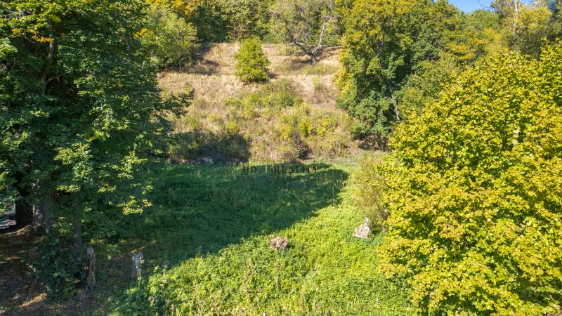 Grünflächen und Bäume auf den Erholungsgrundstücken in Štiavnické Bane unter der Herbstsonne.