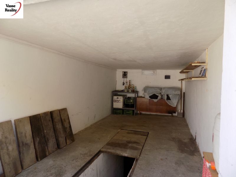 Garage mit Regalen, Straßenboden, Regalen und gelagerten Gegenständen.