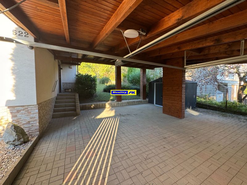 Garage und Eingang zum Einfamilienhaus in Valča 533, Valča, mit gepflastertem Bereich.