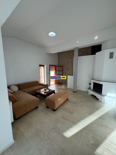 Wohnzimmer in einem Einfamilienhaus mit Kamin und geräumiger Sitzgarnitur.