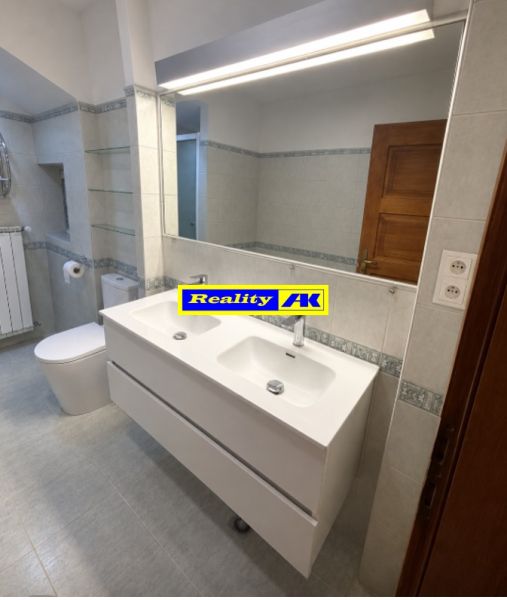 Badezimmer mit Doppelwaschbecken und großem Spiegel in einem Einfamilienhaus.
